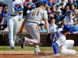 Kris Bryant (#17), de los Cachorros de Chicago, libra el out de Josh Osich (#61), de los Gigantes de San Francisco. AFP / J. Durr