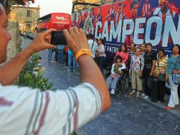 Varios turistas quisieron fotografiarse frente a uno de los autobuses que ayer transportó a los jugadores de las Chivas. EL INFORMADOR / E. Barrera