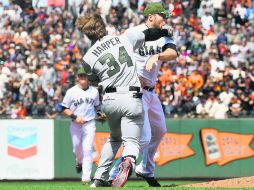 Bryce Harper (#34) lanza un puñetazo al rostro de Hunter Strickland, quien lo golpeó de manera intencional con la bola el lunes pasado. AFP /