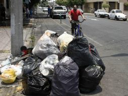 Un ciclista evita la acumulación de desechos en el cruce de Esteban Loera y la calle Pedro María Anaya. EL INFORMADOR / A. Camacho