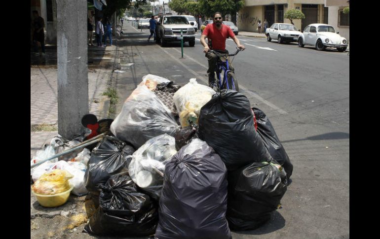 Un ciclista evita la acumulación de desechos en el cruce de Esteban Loera y la calle Pedro María Anaya. EL INFORMADOR / A. Camacho