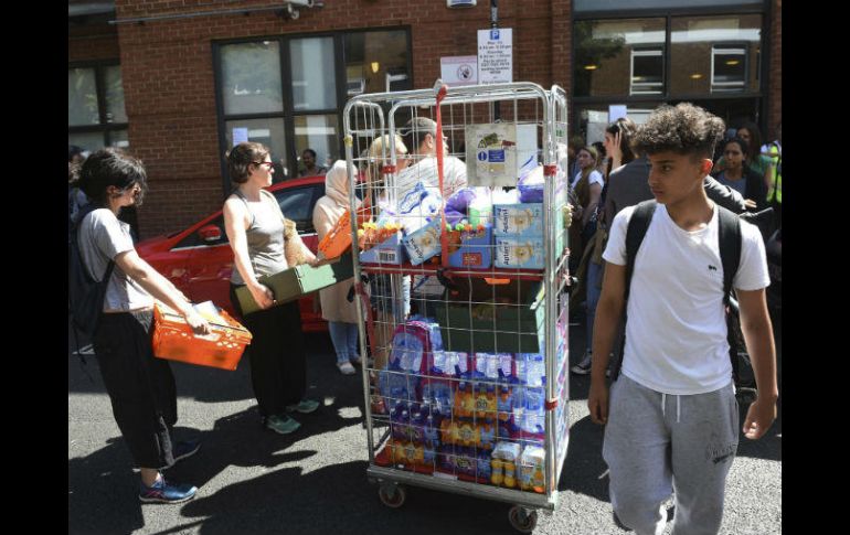 Voluntarios llevan agua y comida a los afectados por el incendio. EFE / F. Arrizabalaga