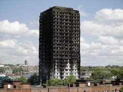 La primera ministra británica  visitó el edificio calcinado en el que bomberos buscaban a los numerosos desaparecidos. AFP / T. Akmen