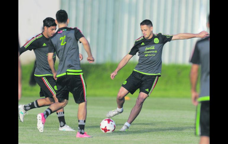 Práctica ligera. 'Chicharito' patea el balón junto a Carlos Vela e Hirving Lozano. AP /