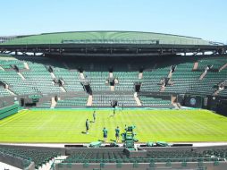 Trabajadores dan los últimos toques a la cancha central del All England Club, que desde hoy recibe a los mejores tenistas del orbe. AP /