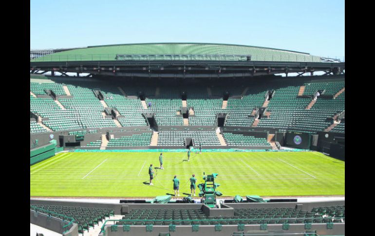 Trabajadores dan los últimos toques a la cancha central del All England Club, que desde hoy recibe a los mejores tenistas del orbe. AP /