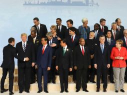 Trump quedó en uno de los extremos para la foto, entre el presidente indonesio Joko Wododo, y el mandatario francés Macron. AFP / POOL / L. Marin