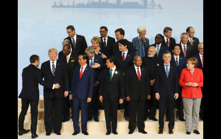 Trump quedó en uno de los extremos para la foto, entre el presidente indonesio Joko Wododo, y el mandatario francés Macron. AFP / POOL / L. Marin