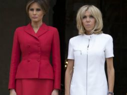 Melania lucía un elegante conjunto de falda y chaqueta rojo Dior y Brigitte Macron llevaba un vestido corto blanco y zapatos azules. EFE / I. Langsdon