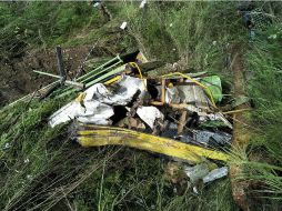 El autobús se salió de la carretera y rodó colina abajo unos 300 metros hasta estrellarse en la ribera de un río y quedar destrozado. AFP / STR