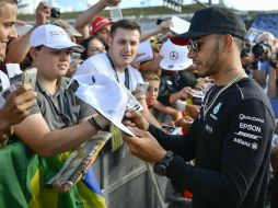 Lewis Hamilton firma autógrafos a los fanáticos que se dieron cita ayer en el Circuito de Hungaroring. AP / Z. Czegledi