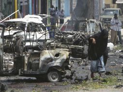 Una mujer camina entre varios vehículos que resultaron afectados tras la explosión. EFE / S. Yusuf