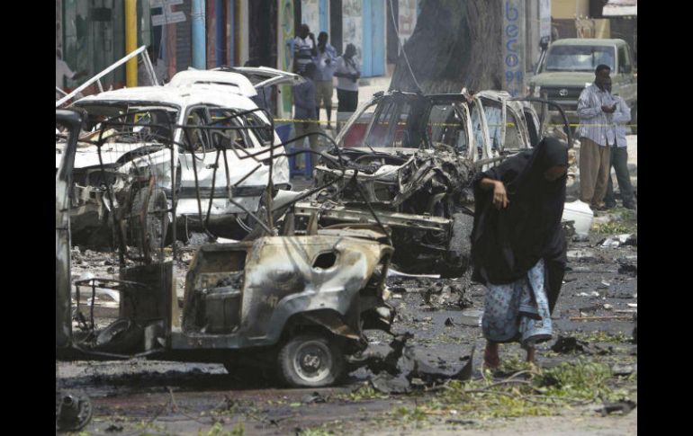 Una mujer camina entre varios vehículos que resultaron afectados tras la explosión. EFE / S. Yusuf