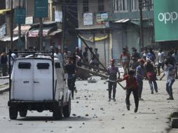 Musulmanes cachemiros atacan a un vehículo de la policía india durante una ola de disturbios. EFE / F. Khan