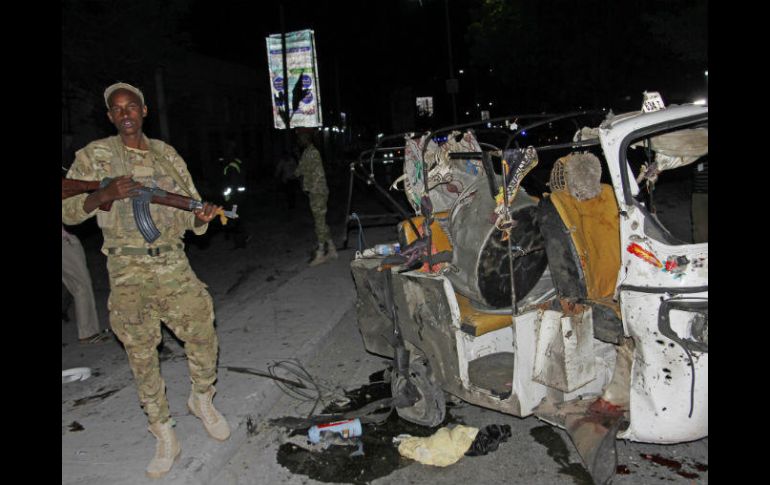 Un soldado permanece al lado de uno de los vehículos afectados por la explosión. AP / F. Warsameh