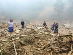 Familias vietnamitas observan a lo que quedaron reducidos sus hogares, en el distrito de Mu Cang Chai. AFP / ARCHIVO