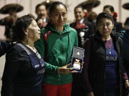 La atleta abrió un fardo, donde guardaba la medalla, y después se la colocó en el cuello. SUN / C. Rogel Blanquet