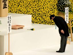 El primer ministro de Japón, Shinzo Abe, se inclina tras colocar una flor en un altar durante la ceremonia. AFP / T. Yamanaka