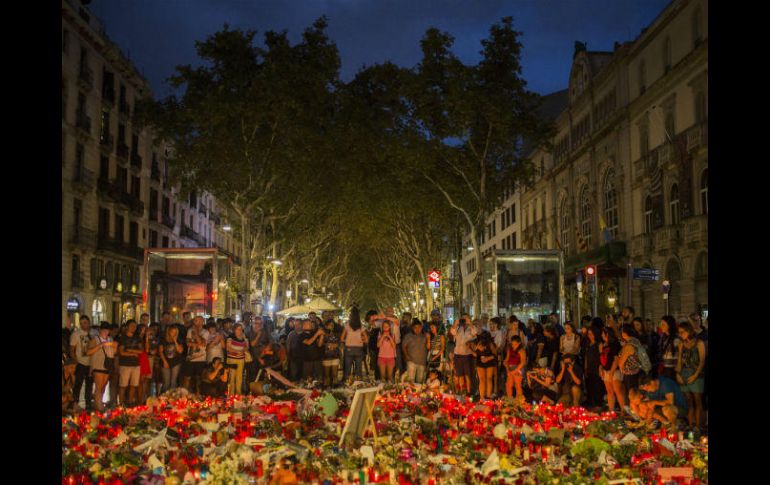 Decenas de personas oran frente a un memorial erigido para recordar a las víctimas. AP / S. Palacios