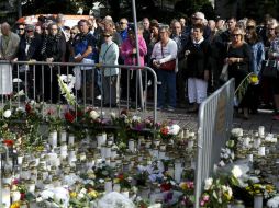 Varias personas homenajean a las víctimas de esta agresión con un minuto de silencio. AP / V. Moilanen