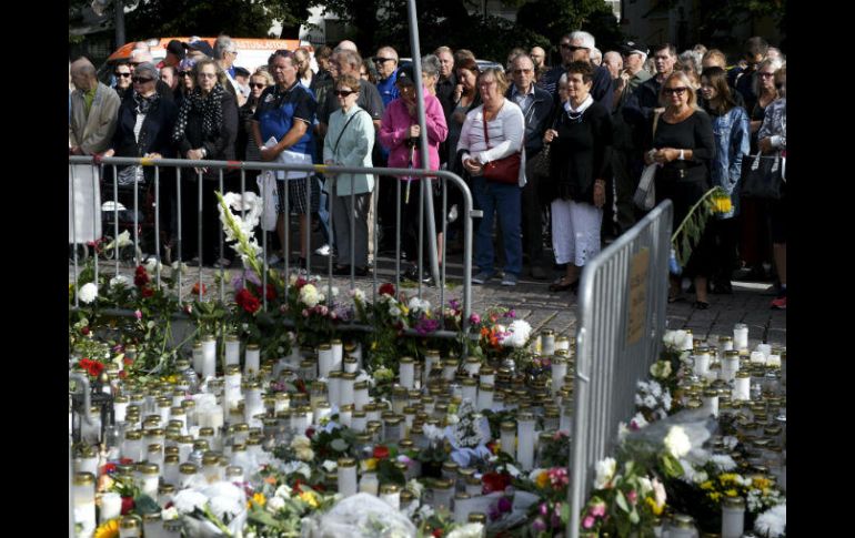 Varias personas homenajean a las víctimas de esta agresión con un minuto de silencio. AP / V. Moilanen