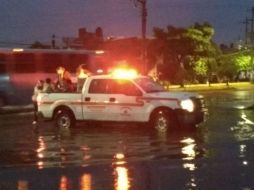 Bomberos de Guadalajara ayudan a algunas personas a cruzar las calles inundadas. ESPECIAL /