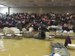 La gente se fue hacia las gradas para evitar la inundación, pero las pocas pertenencias que había rescatado quedaron bajo el agua. AP / B. Johnson