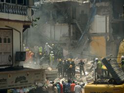 Equipos de rescate apartan a mano los restos del edificio derrumbado, ayudados por al menos una grúa de grandes dimensiones. AFP / P. Paranjpe