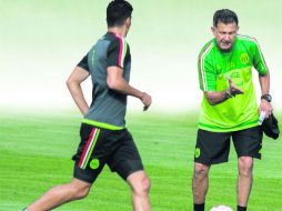 Instrucciones. Juan Carlos Osorio explica gráficamente a Raúl Jiménez cómo debe hacer sus movimientos en la cancha. MEXSPORT /