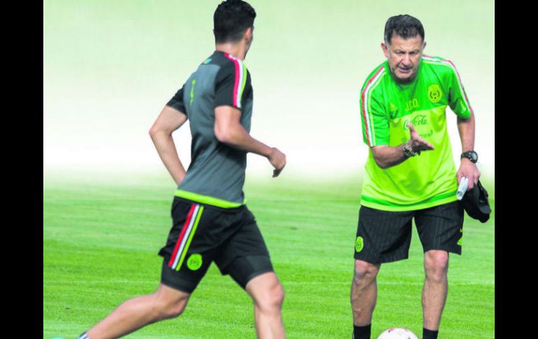 Instrucciones. Juan Carlos Osorio explica gráficamente a Raúl Jiménez cómo debe hacer sus movimientos en la cancha. MEXSPORT /