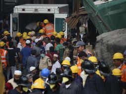 La Fuerza Nacional de Respuesta de Desastres (NDRF) llevan un cuerpo sin vida encontrado en el edificio derrumbado en Bombay. EFE / D. Solanki