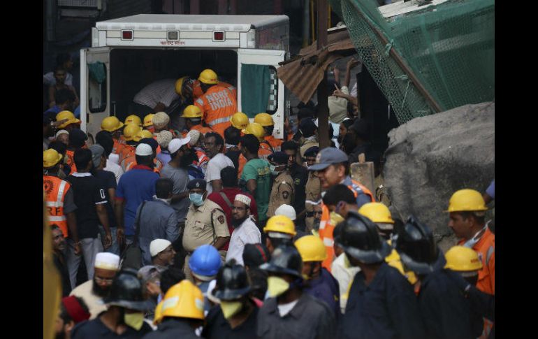 La Fuerza Nacional de Respuesta de Desastres (NDRF) llevan un cuerpo sin vida encontrado en el edificio derrumbado en Bombay. EFE / D. Solanki