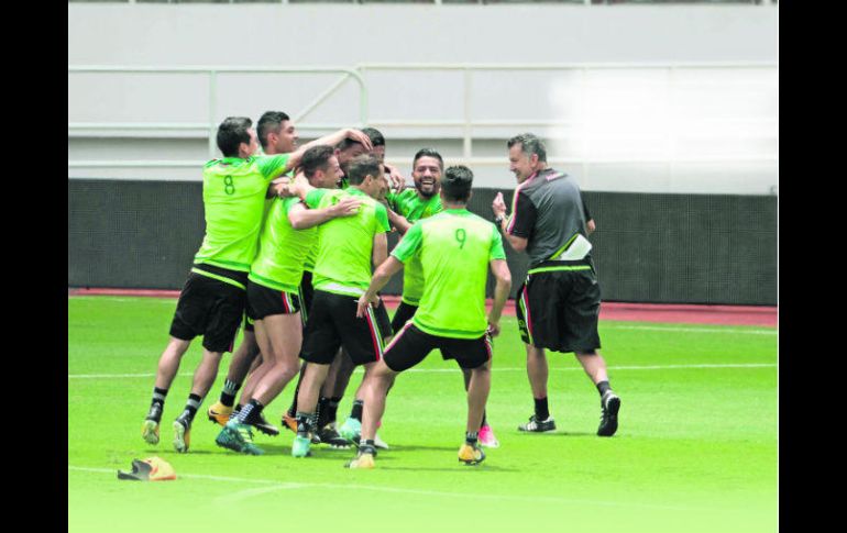 Buen ambiente. Los jugadores del Tricolor bromean durante la práctica, acción a la que se suma el DT Juan Carlos Osorio. EFE /