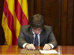 El presidente de la Generalitat, Carles Puigdemont firma la convocatoria del referéndum tras la aprobación de la ley hoy mismo. EFE / A. García