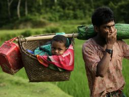 Un refugiado rohinyá porta a su bebé en un cesto a su llegada a Tuangiri, en Teknaf, Bangladesh. EFE / A. Abdullah