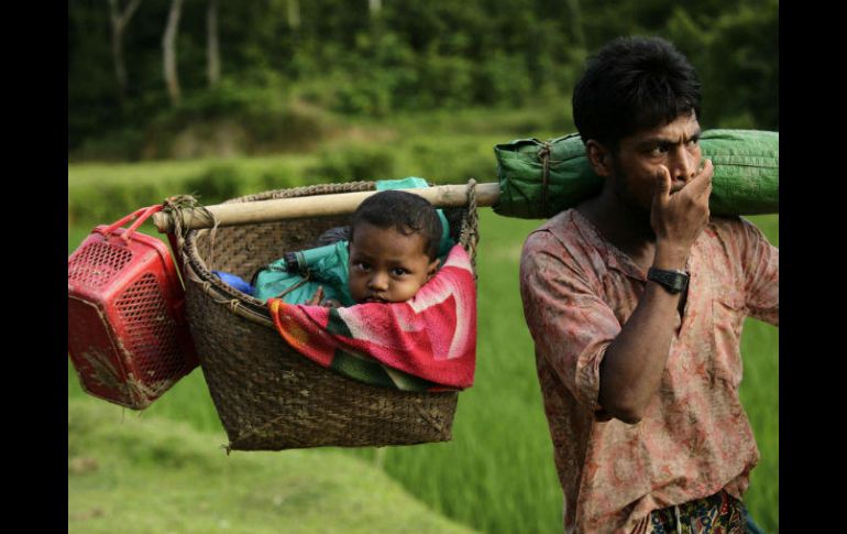 Un refugiado rohinyá porta a su bebé en un cesto a su llegada a Tuangiri, en Teknaf, Bangladesh. EFE / A. Abdullah