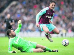 El portero del West Bromwich Albion, Ben Foster, se desliza bajo Javier 'Chicharito' Hernández (d), del West Ham United en el Hawthorn. AP /