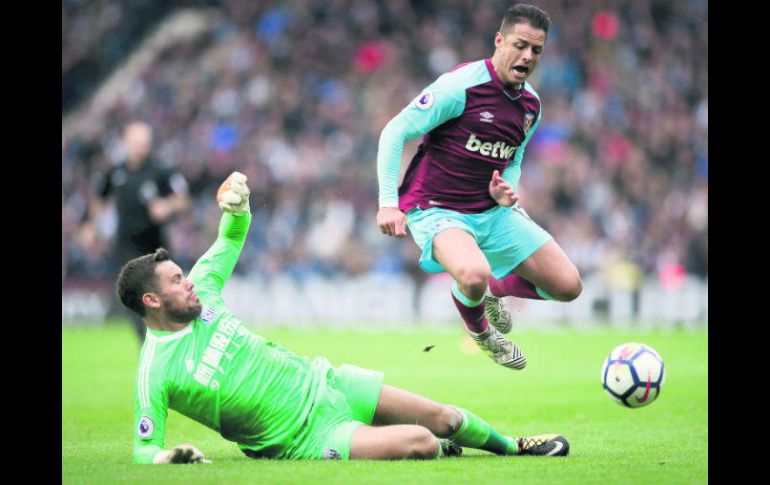 El portero del West Bromwich Albion, Ben Foster, se desliza bajo Javier 'Chicharito' Hernández (d), del West Ham United en el Hawthorn. AP /