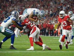 A las diagonales. El quarterback de Dallas, Dak Prescott (#4), salta para llegar a la zona de anotación.