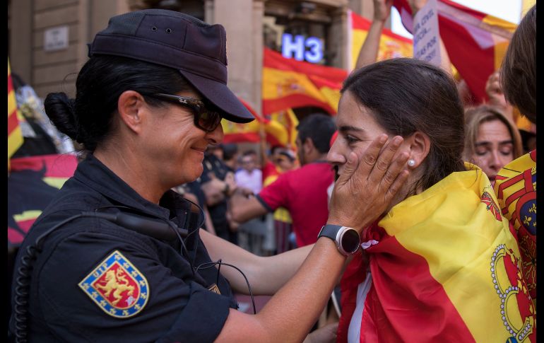 Una policía habla con una manifestante. Esta demostración se da a dos días de la celebración del pleno del Parlamento regional en el que podría declararse unilateralmente la independencia. AP/E. Morenatti