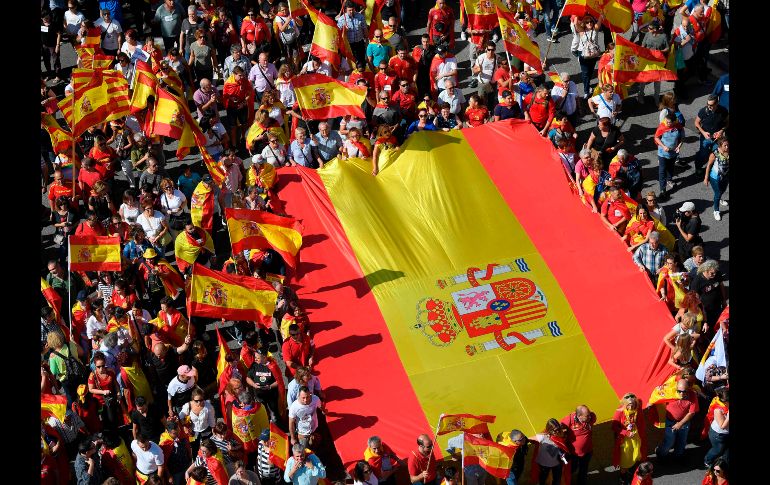 Una bandera gigante de España se despliega en la marcha. AFP/L. Gene