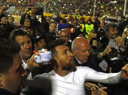 Messi, rodeado de una multitud, arroja su camiseta hacia un numeroso grupo de fanáticos. AFP/J. Cazar