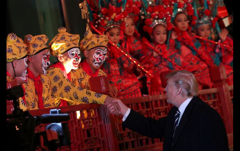 El presidente Donald Trump (d) saluda a artistas de la ópera durante un tour en Pekín, en el marco de su visita oficial a China. AP/A. Harnik