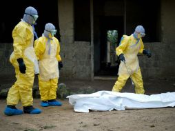 Personal sanitario se prepara para trasladar el cadáver de una víctima del ébola. AFP / K. Tribouillard