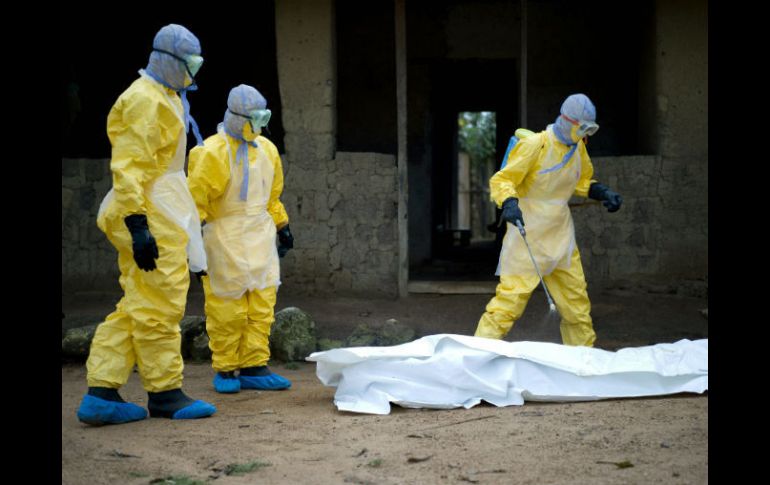 Personal sanitario se prepara para trasladar el cadáver de una víctima del ébola. AFP / K. Tribouillard