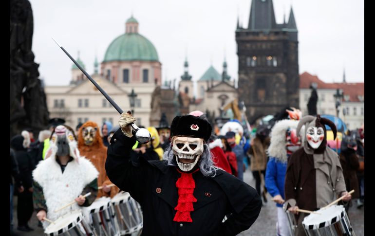 Personas con máscaras marchan por el puente Carlos en Praga, República Checa, en el marco de las conmemoraciones por el 28 aniversario de la llamada Revolución de Terciopelo. AP/P. David