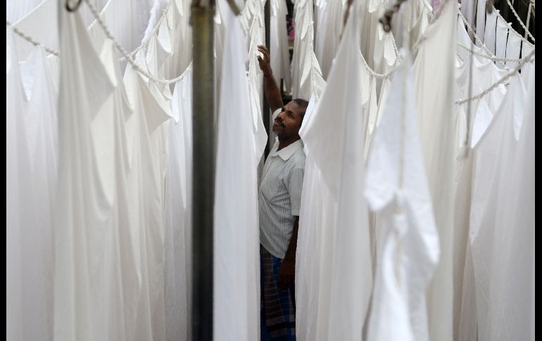 Un trabajador cuelga sábanas limpias en una lavandería de Chennai, India. AFP/A. Sankar