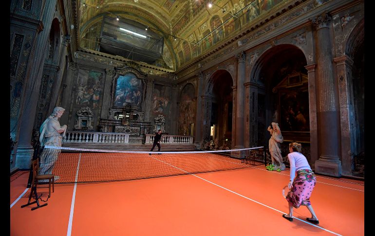 Personas juegan tenis en la nueva instalación artística de Asad Raza, una cancha de tenis dentro de la igesia San Paolo Converso en Milán, Italia.  AFP / M. Medina