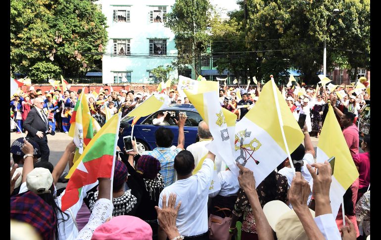 Una multitud saluda al Papa Francisco (c) que pasa en un automóvil por las calles de Rangún, Birmania. El Papa llegó hoy al país en una visita de cuatro días. AFP/Y. Aung Thu
