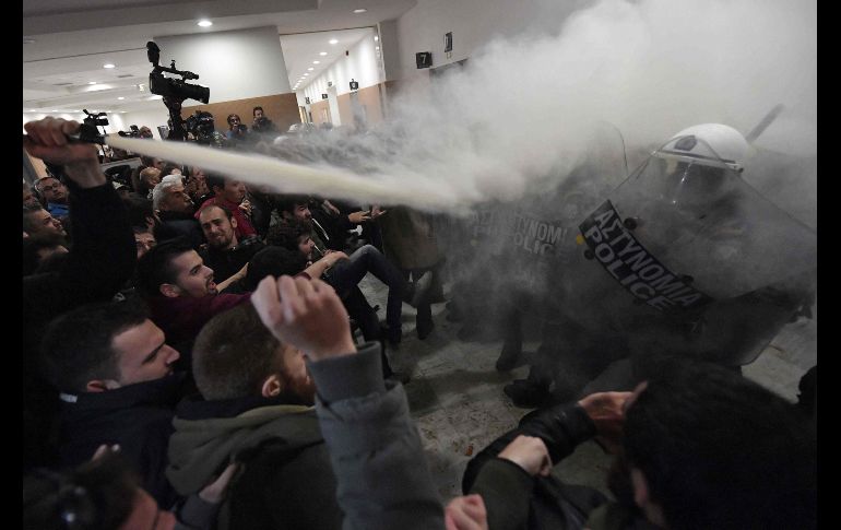 Un enfrentamiento entre policías y manifestantes se registra en el pasillo de una corte en Atenas. Habitantes protestan contra las subastas de viviendas contempladas bajo las reformas del rescate financiero de Grecia. AFP/L. Gouliamaki